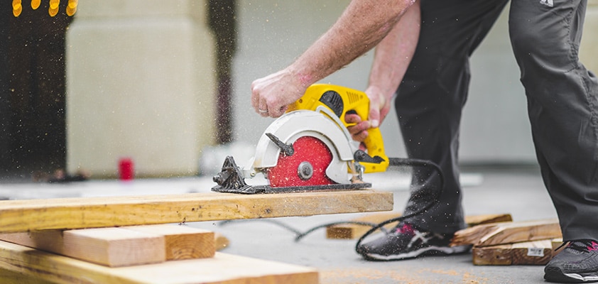Homme se servant d'une scie circulaire